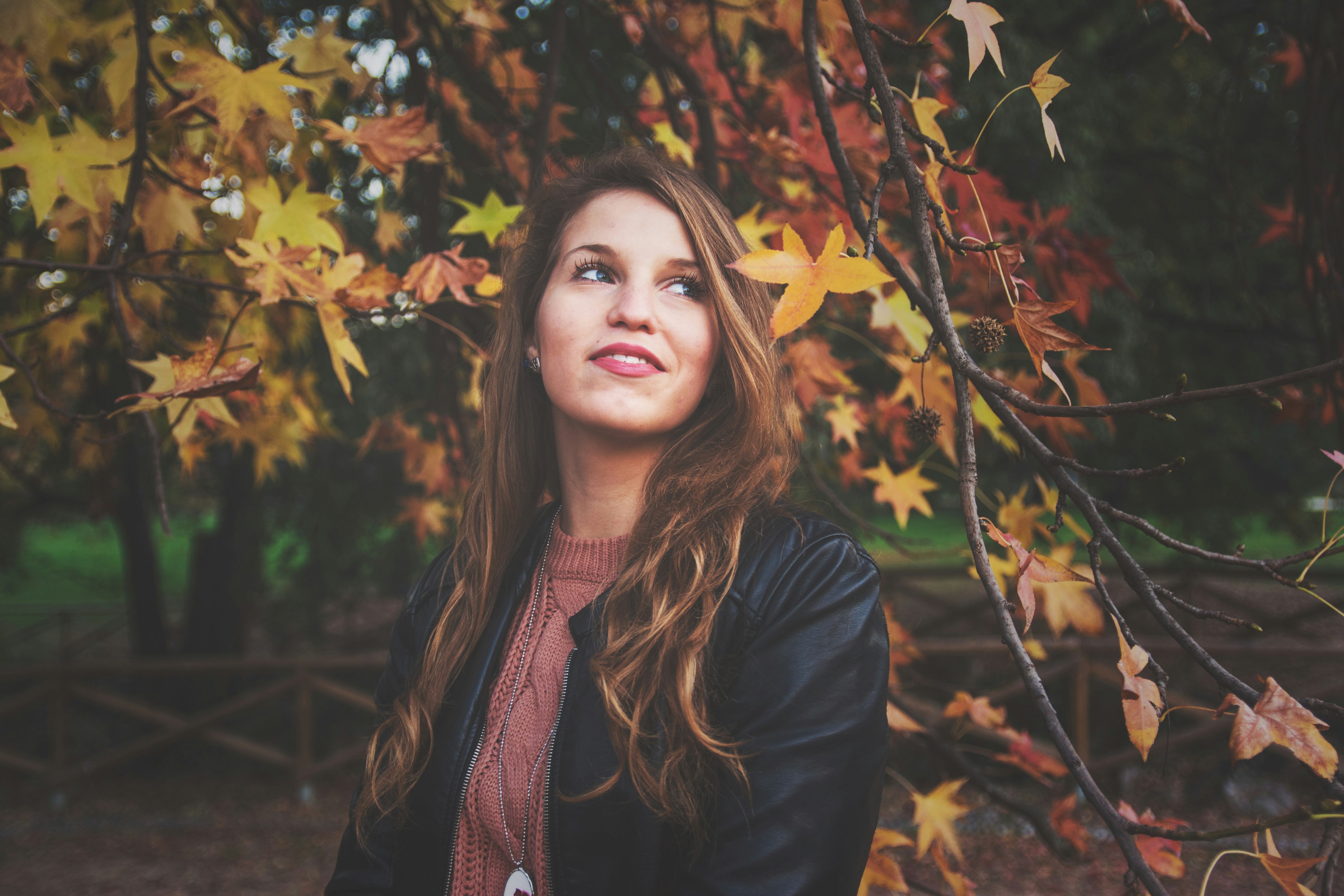 woman beside maple leaf tree